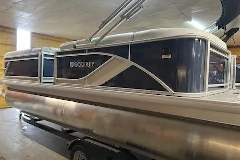 The Image of 2026 Sweetwater 2286C pontoon boat on trailer, parked outdoors under cloudy sky. - 0