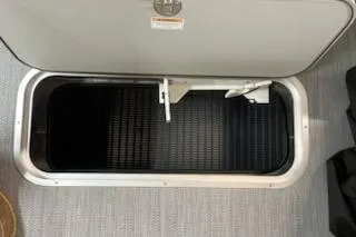 Slide: The Image of Sweetwater 2286C 2026 boat storage compartment with open hatch, showcasing interior space. - 11