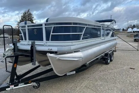 Slide: The Image of 2026 Sweetwater 2286C pontoon boat on trailer, parked outdoors under cloudy sky. - 22