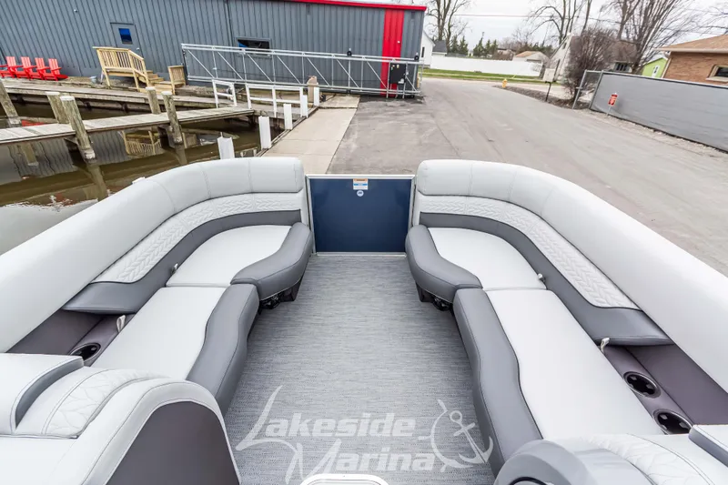 Slide: The Image of 2025 Godfrey Monaco 235 SFL pontoon boat interior with luxurious seating at marina. - 14