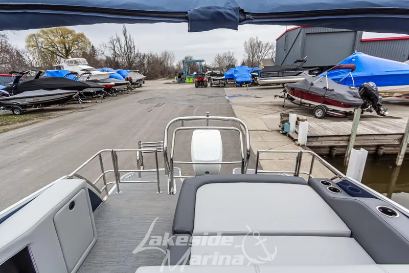 Slide: The Image of 2025 Godfrey Monaco 235 SFL at marina, surrounded by covered boats and docks. - 28