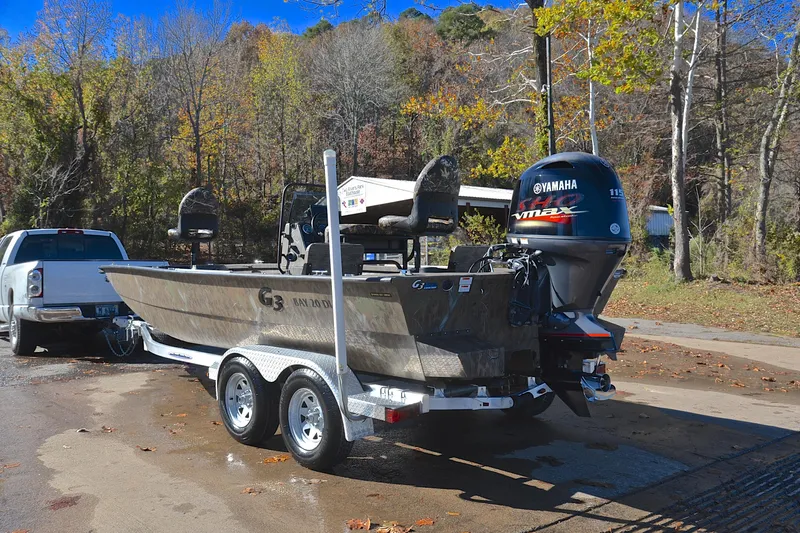 Slide: The Image of 2017 G3 Bay 20 DLX Camo boat on trailer with Yamaha engine, parked outdoors. - 12