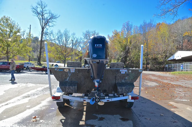 Slide: The Image of 2017 G3 Bay 20 DLX Camo boat on trailer, parked outdoors in autumn setting. - 13