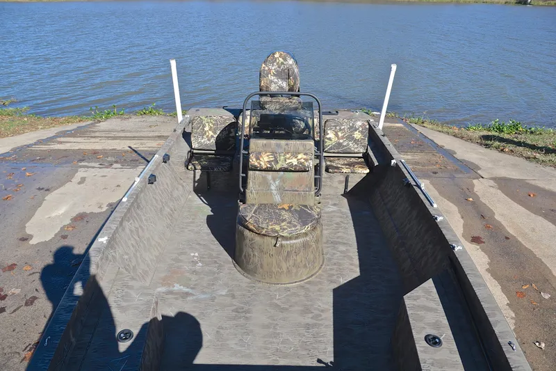 Slide: The Image of 2017 G3 Bay 20 DLX Camo boat on a ramp by a lake. - 23