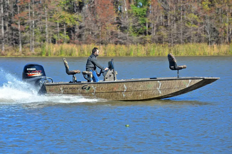 Slide: The Image of 2017 G3 Bay 20 DLX Camo boat speeding on a lake with a Yamaha engine. - 3