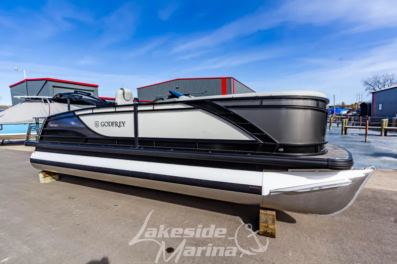 The Image of 2025 Godfrey Monaco 235 SFL pontoon boat at Lakeside Marina, under clear blue sky. - 1