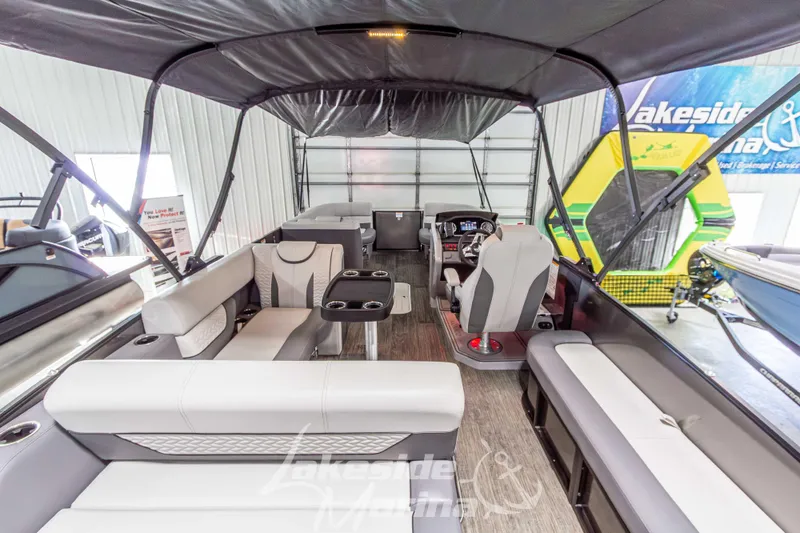 Slide: The Image of 2025 Godfrey Monaco 235 SFL pontoon boat interior with seating and helm, in showroom. - 28