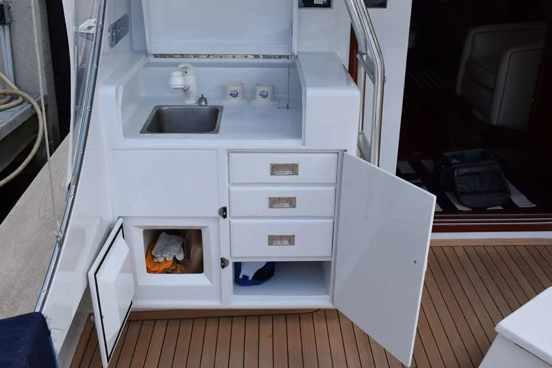 Slide: The Image of 1960 Rybovich Sportfisherman boat kitchen with sink and storage. - 28
