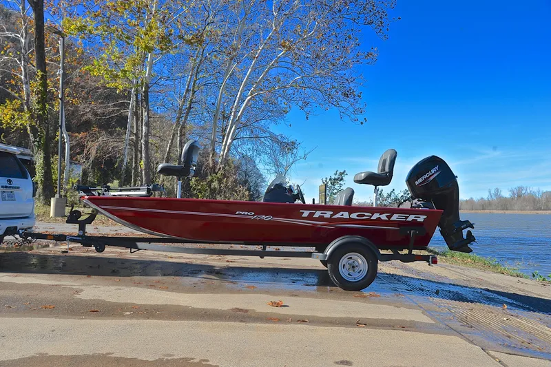 Slide: The Image of 2024 Tracker Pro 170 boat on trailer by a lakeside, ready for launch. - 11