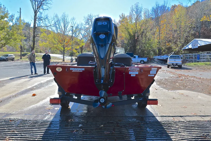 Slide: The Image of 2024 Tracker Pro 170 boat on trailer at a sunny lakeside launch area. - 13