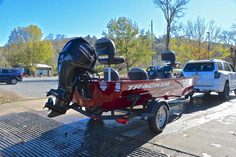 Slide: The Image of 2024 Tracker Pro 170 boat on trailer, parked outdoors in sunny setting. - 14