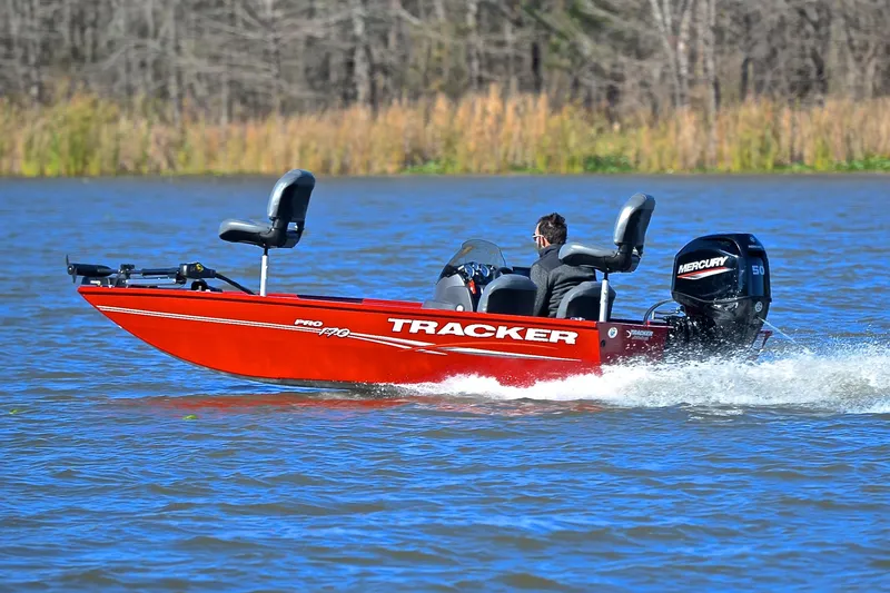 Slide: The Image of 2024 Tracker Pro 170 boat cruising on a lake with Mercury engine. - 4