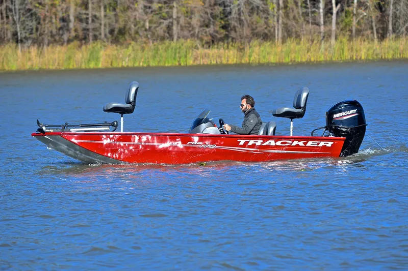 Slide: The Image of 2024 Tracker Pro 170 boat cruising on a lake with a Mercury engine. - 9