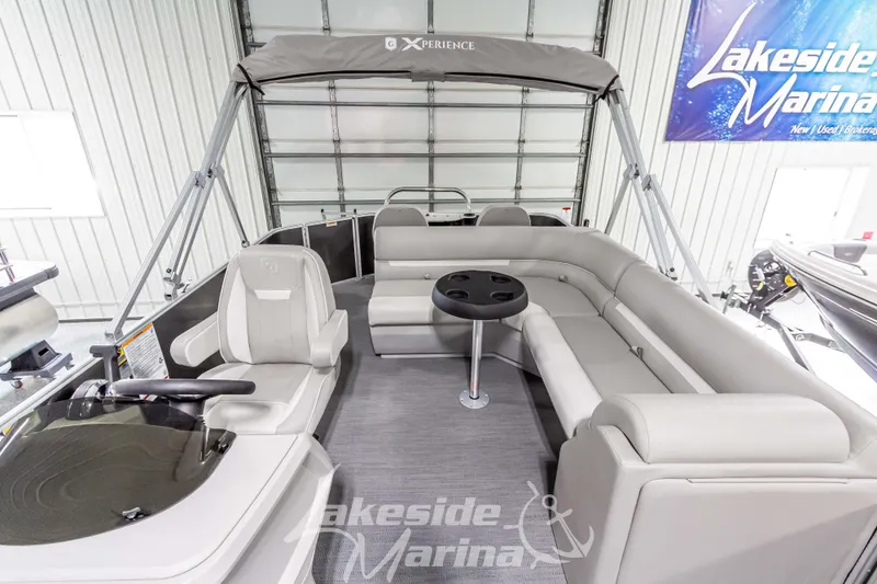 Slide: The Image of 2025 Godfrey Sweetwater 2286 FSX pontoon boat interior with seating and table at Lakeside Marina. - 17