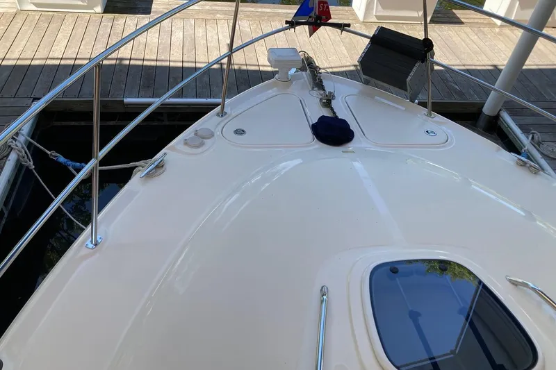 Slide: The Image of 2008 Sea Ray 44 Sundancer yacht bow view at dock, showcasing deck and railings. - 13