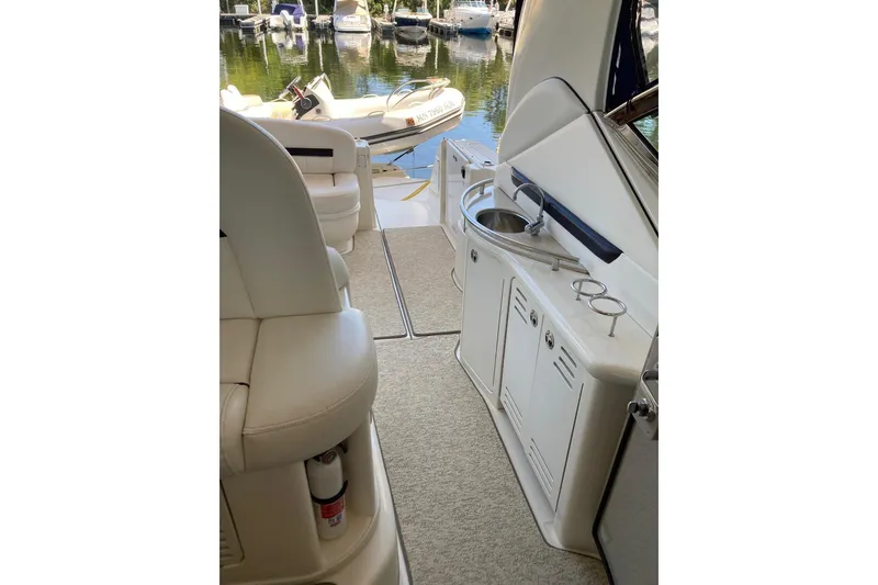 Slide: The Image of 2008 Sea Ray 44 Sundancer yacht interior with seating and kitchenette, docked at marina. - 30