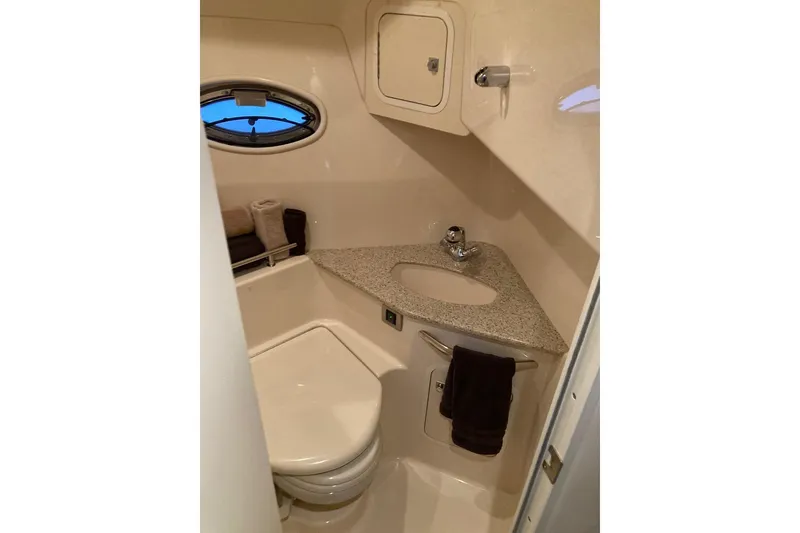Slide: The Image of 2008 Sea Ray 44 Sundancer bathroom with compact design, granite countertop, and porthole window. - 46