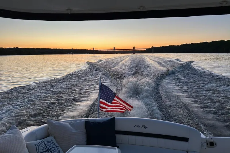 Slide: The Image of American flag on 2008 Sea Ray 44 Sundancer, cruising at sunset with bridge in background. - 55