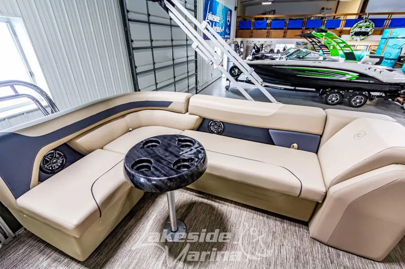 Slide: The Image of 2025 Godfrey Sweetwater 2286 C pontoon boat interior with beige seating and black table. - 23