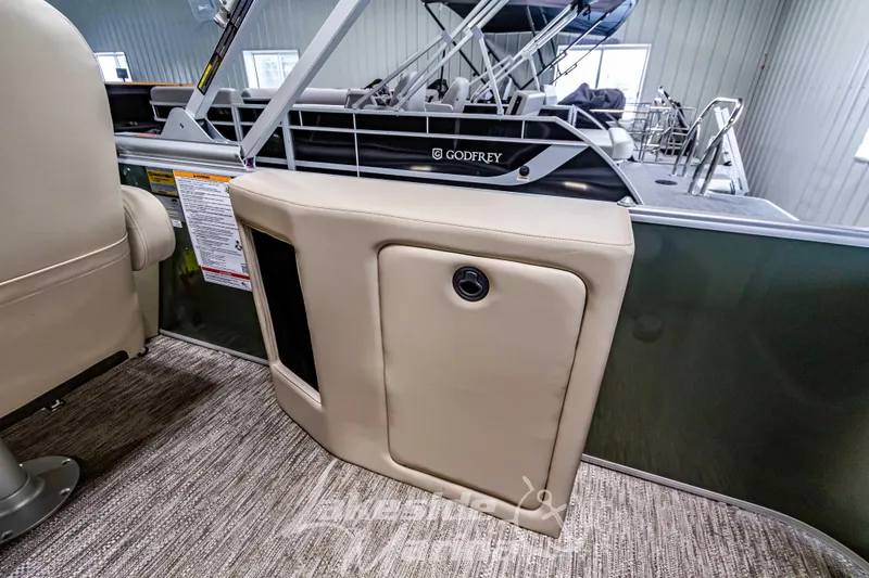 Slide: The Image of 2025 Godfrey Sweetwater 2286 C boat interior with beige seating and storage compartment. - 26