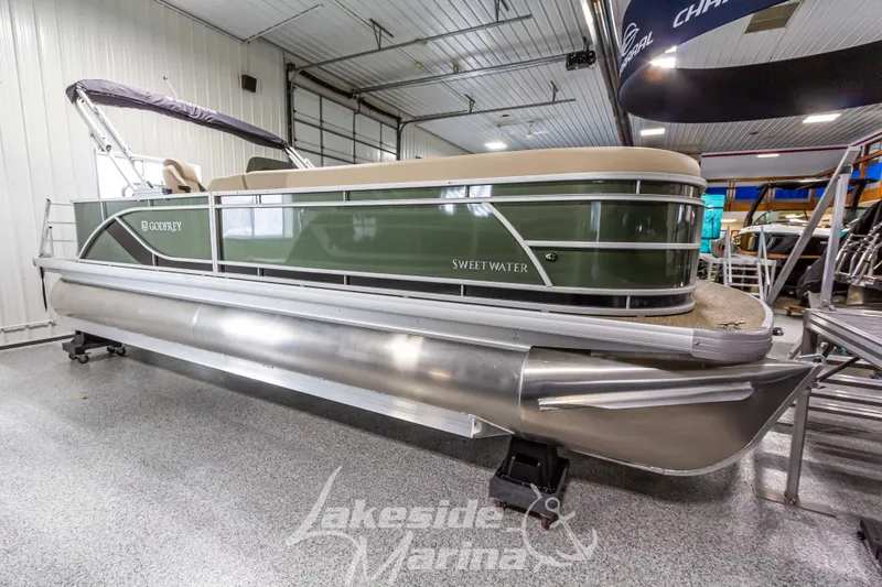 Slide: The Image of 2025 Godfrey Sweetwater 2286 C pontoon boat in showroom, green exterior, Lakeside Marina. - 5