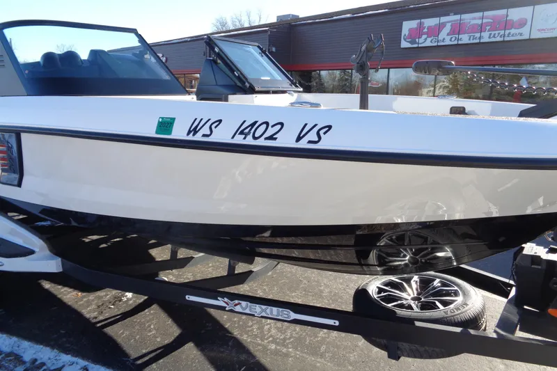 Slide: The Image of 2021 Vexus DVX20 boat on trailer, displayed outside dealership. - 12