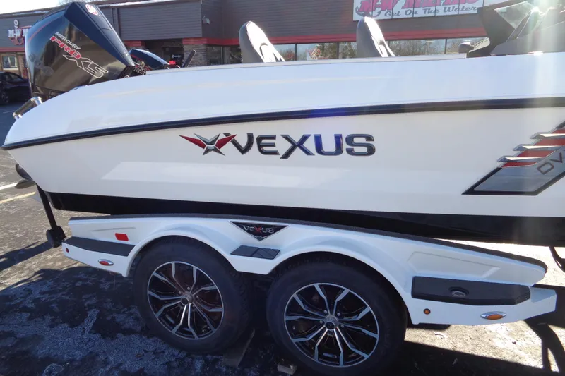 Slide: The Image of 2021 Vexus DVX20 boat on trailer, featuring sleek design and dual wheels. - 13