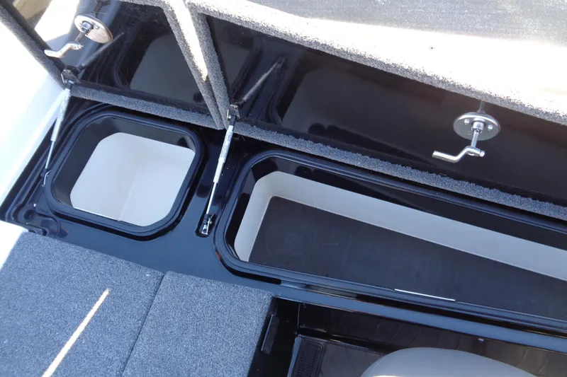 Slide: The Image of 2021 Vexus DVX20 boat storage compartments with open lids and carpeted flooring. - 37