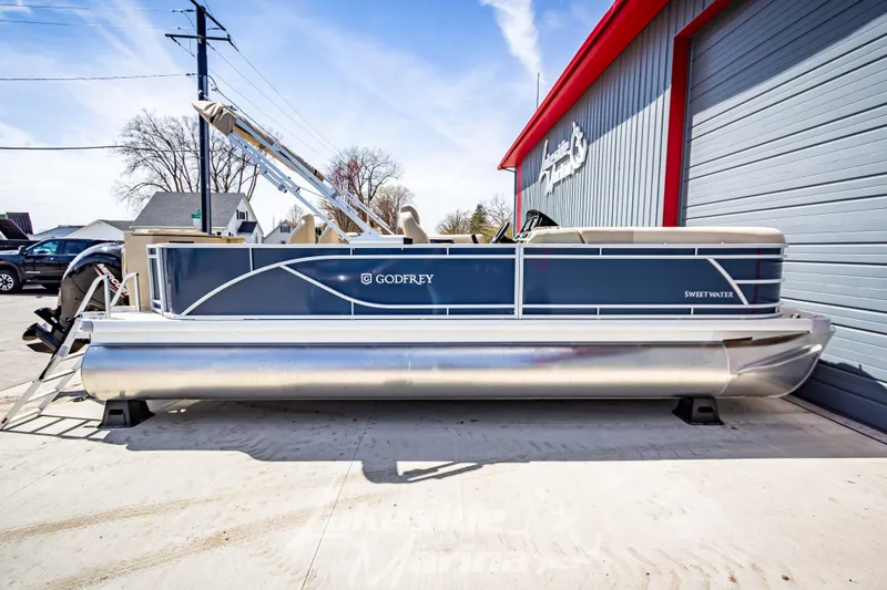 Slide: The Image of 2025 Godfrey Sweetwater 2286 FSX pontoon boat parked outside a marine shop. - 8