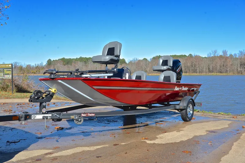 Slide: The Image of 2023 Bass Tracker Classic boat on trailer by a lake under clear blue sky. - 10