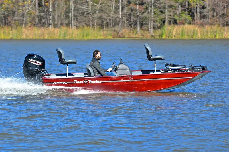 Slide: The Image of 2023 Bass Tracker Classic boat cruising on a lake with a Mercury engine. - 3