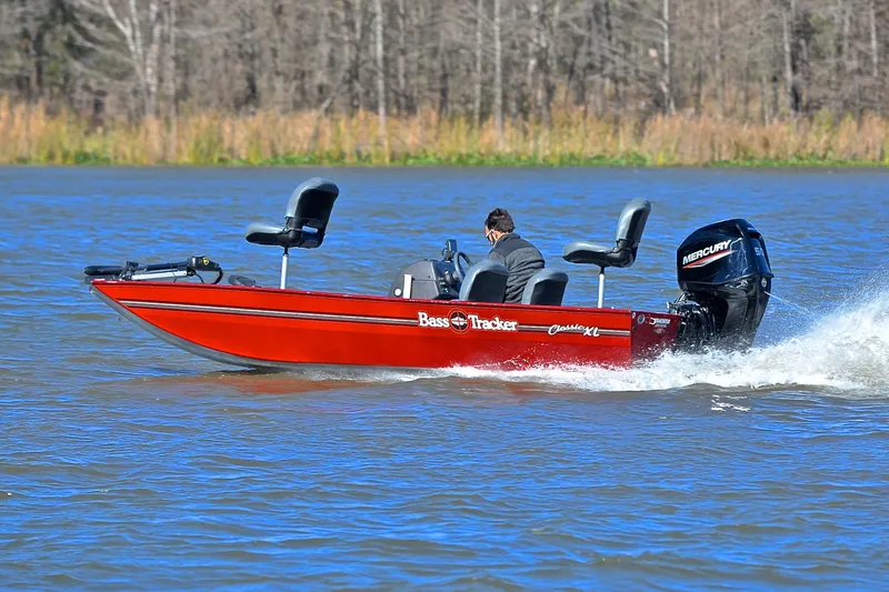 Slide: The Image of 2023 Bass Tracker Classic boat speeding on a lake with a Mercury engine. - 4