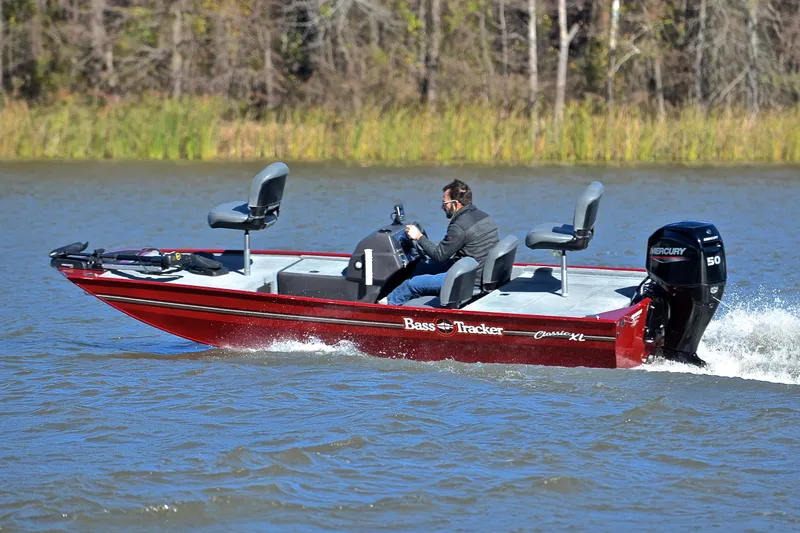 Slide: The Image of 2023 Bass Tracker Classic boat cruising on a lake with a Mercury engine. - 6