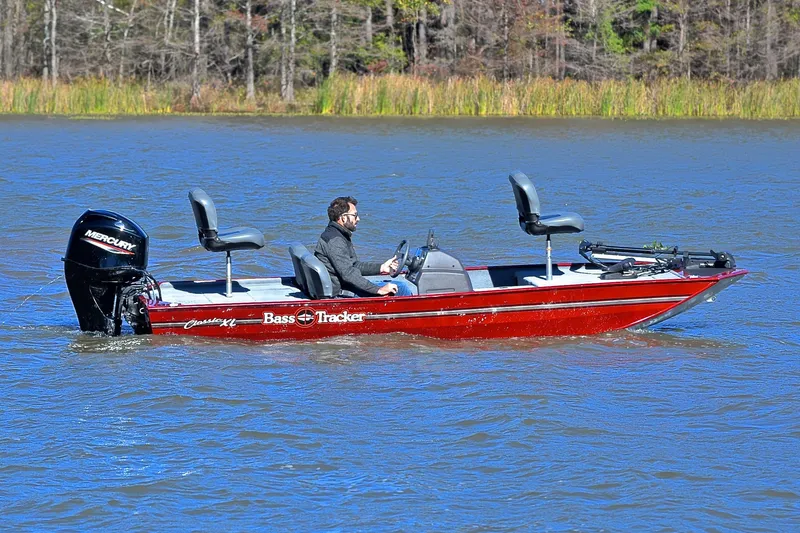 Slide: The Image of 2023 Bass Tracker Classic boat on a lake with a Mercury engine. - 7