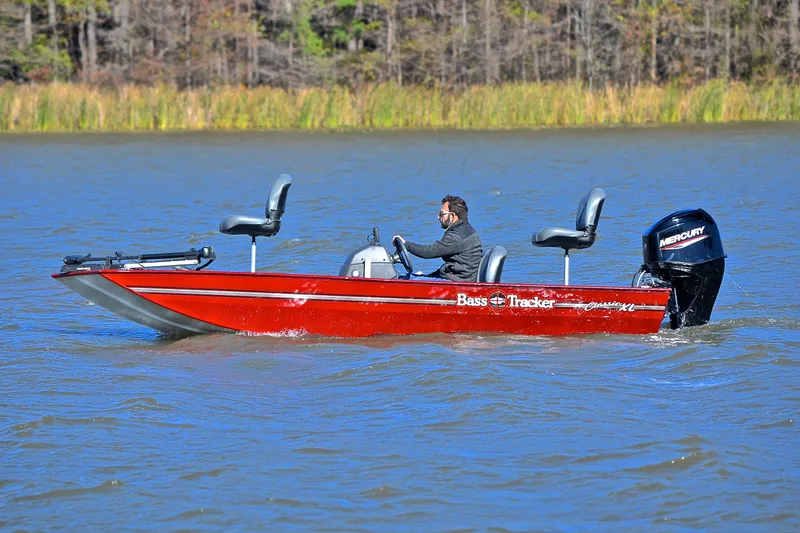 Slide: The Image of 2023 Bass Tracker Classic boat on a lake, featuring a Mercury outboard motor. - 9