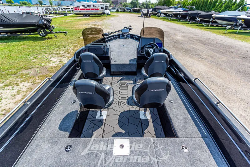 Slide: The Image of 2025 Recon 2185 DC boat interior with four seats, parked outdoors. - 11