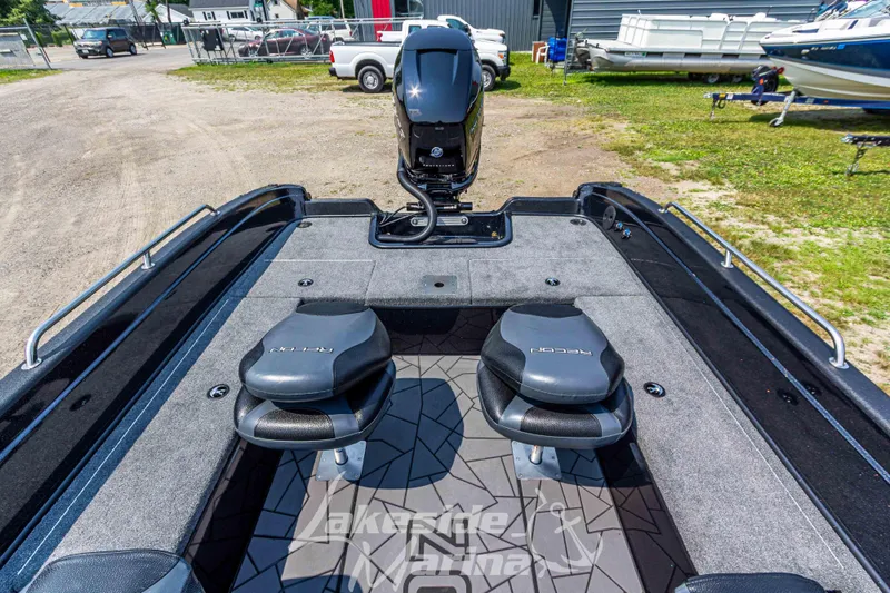 Slide: The Image of 2025 Recon 2185 DC boat interior with dual seats and motor, parked outdoors. - 12
