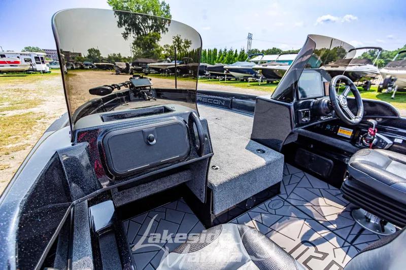 Slide: The Image of 2025 Recon 2185 DC boat interior with dual consoles and seating, displayed outdoors. - 22