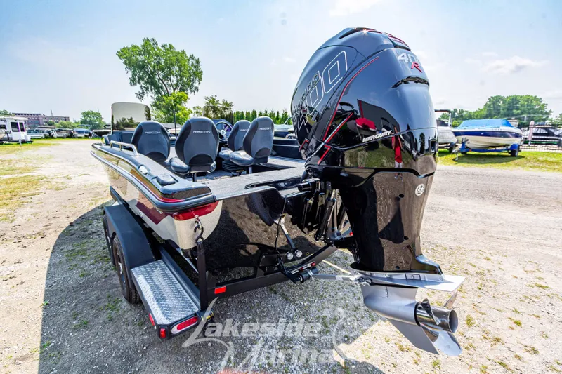 Slide: The Image of 2025 Recon 2185 DC boat with powerful outboard motor, parked outdoors. - 6