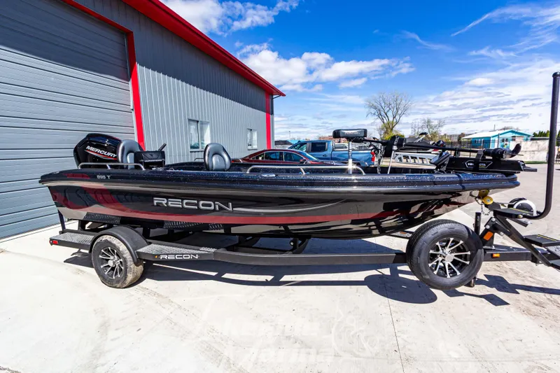 The Image of 2025 Recon 895 Tiller boat on trailer, parked outside a building under a clear sky. - 1