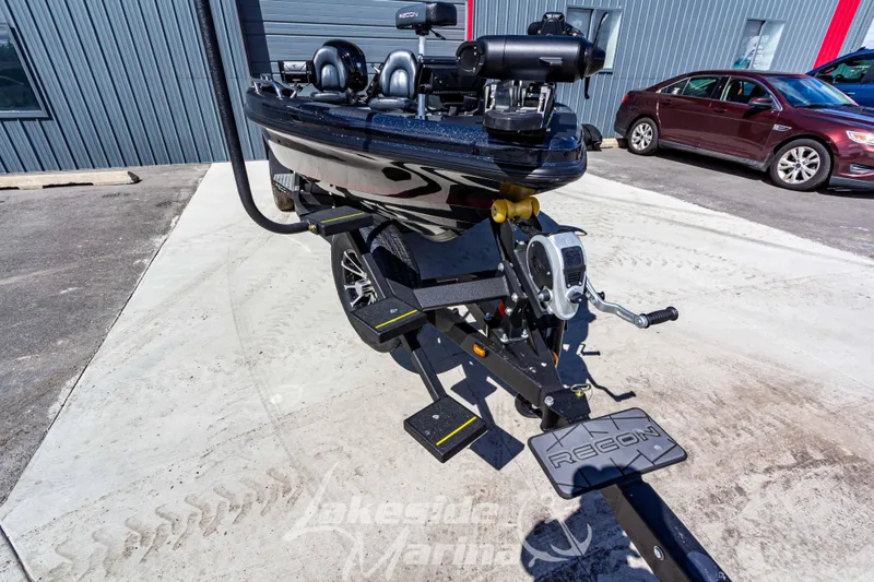 Slide: The Image of 2025 Recon 895 Tiller boat on trailer, parked outside a building. - 10