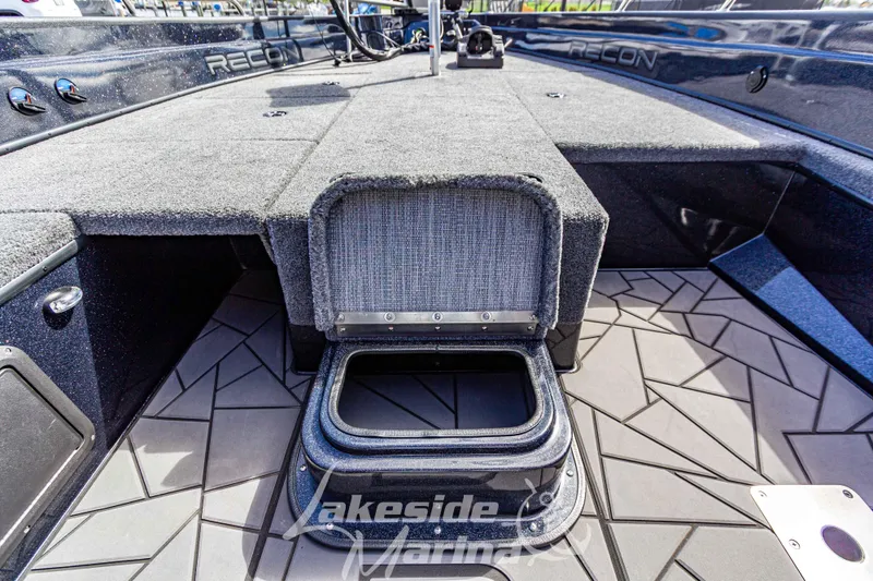 Slide: The Image of 2025 Recon 895 Tiller boat interior with open storage compartment and textured flooring. - 25