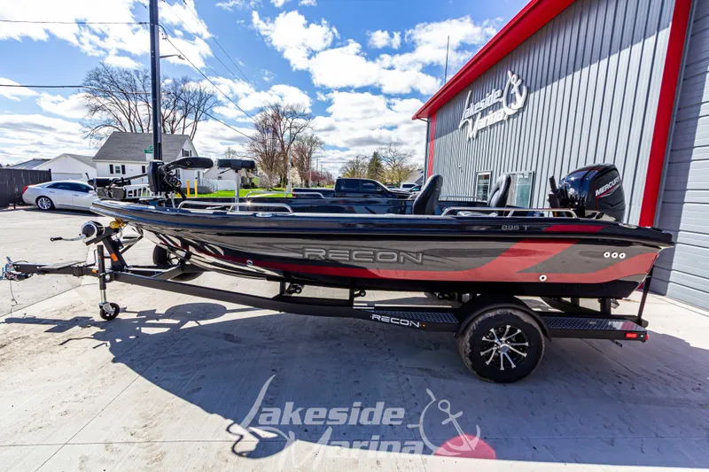 Slide: The Image of 2025 Recon 895 Tiller boat on trailer at Lakeside Marina, under a clear blue sky. - 8