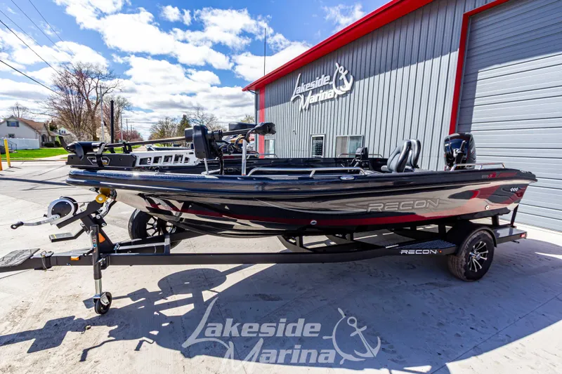 Slide: The Image of 2025 Recon 895 Tiller boat at Lakeside Marina, parked on a trailer under a blue sky. - 9
