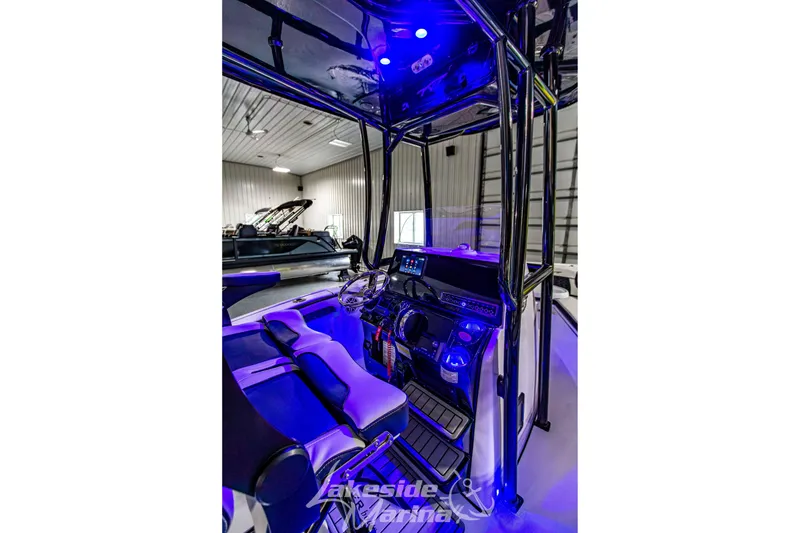 Slide: The Image of 2025 Tidewater 210 LXF boat interior with blue lighting and modern dashboard. - 19