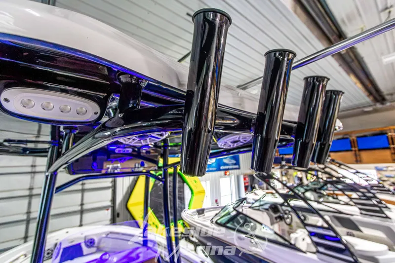 Slide: The Image of 2025 Tidewater 210 LXF boat with rod holders and LED lights in a showroom. - 24