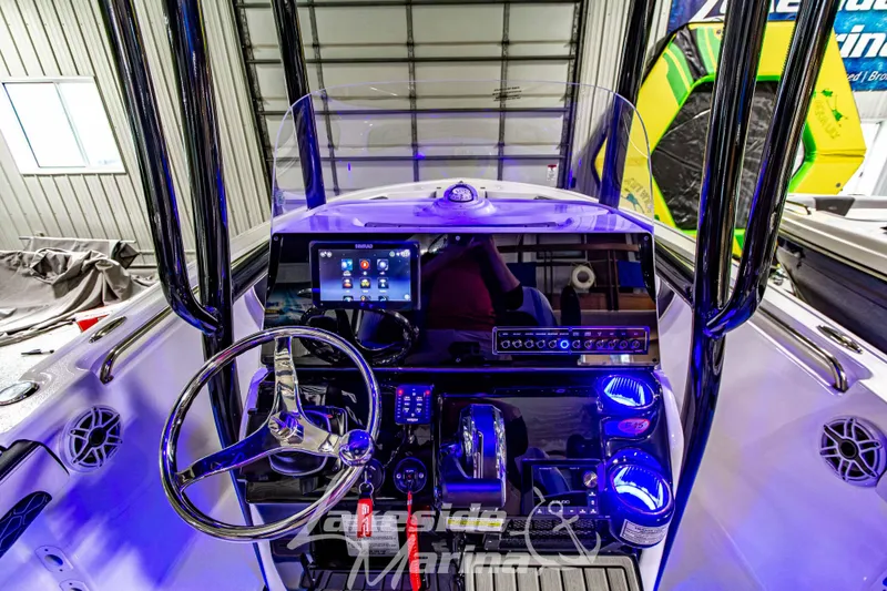 Slide: The Image of 2025 Tidewater 210 LXF boat dashboard with modern controls and illuminated features in a showroom. - 25