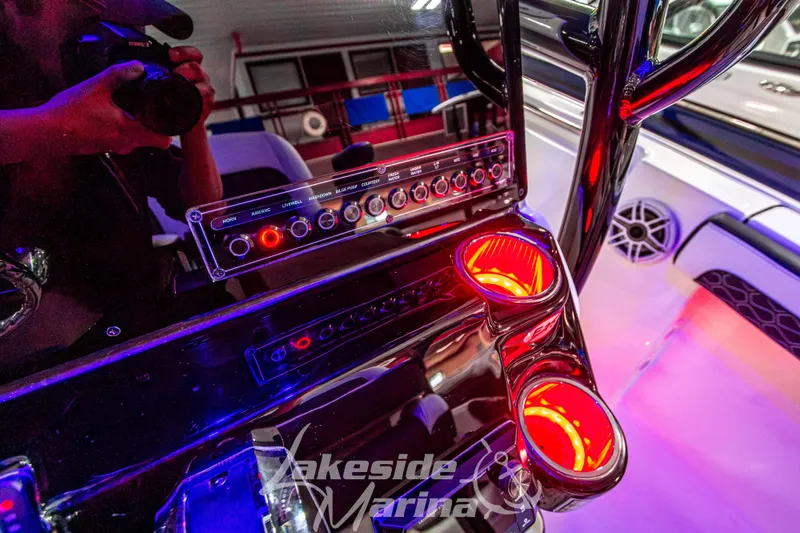 Slide: The Image of 2025 Tidewater 210 LXF boat dashboard with illuminated controls and cup holders. - 27