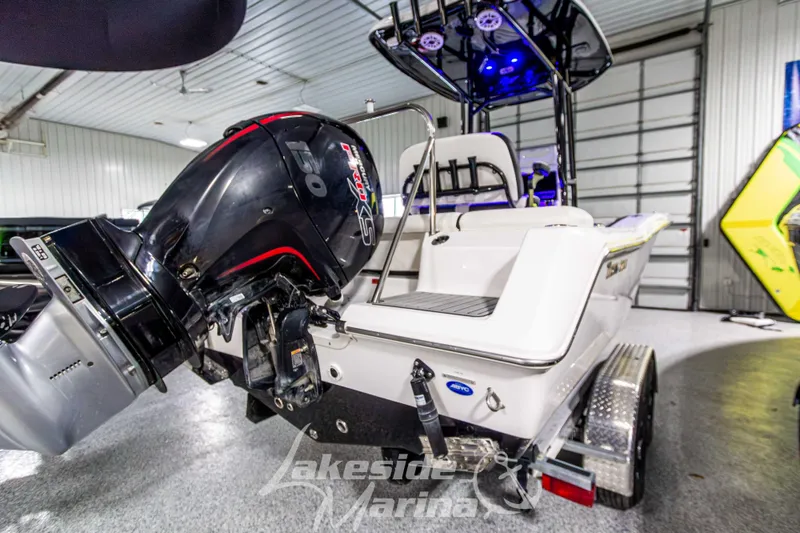 Slide: The Image of 2025 Tidewater 210 LXF boat with powerful outboard motor in a marina showroom. - 6