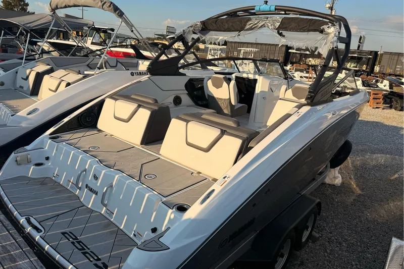 Slide: The Image of 2025 Yamaha Boats 252XE, sleek design, luxury seating, docked in a marina. - 2